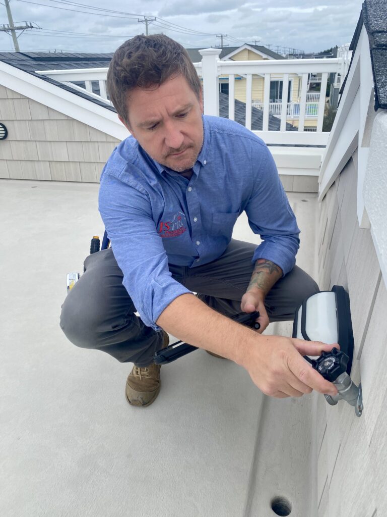 JS Pro working on a roof plumbing during home watch ensuring maintenance and care for residential properties.