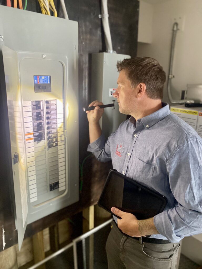 JSPro Management inpecting breaker box and electrical system of a tankless water heater.